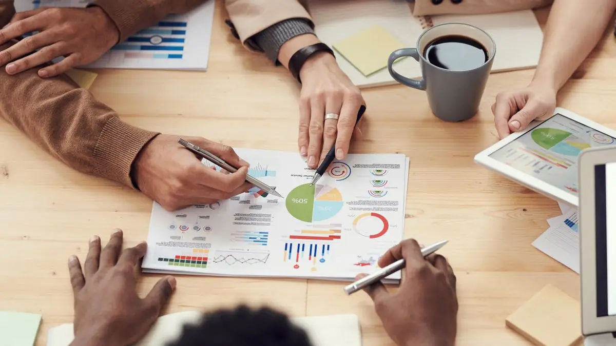 Equipe de vendas reunida analisando gráficos do funil de vendas no CRM